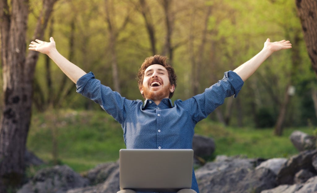 Happy Man with Laptop in Nature